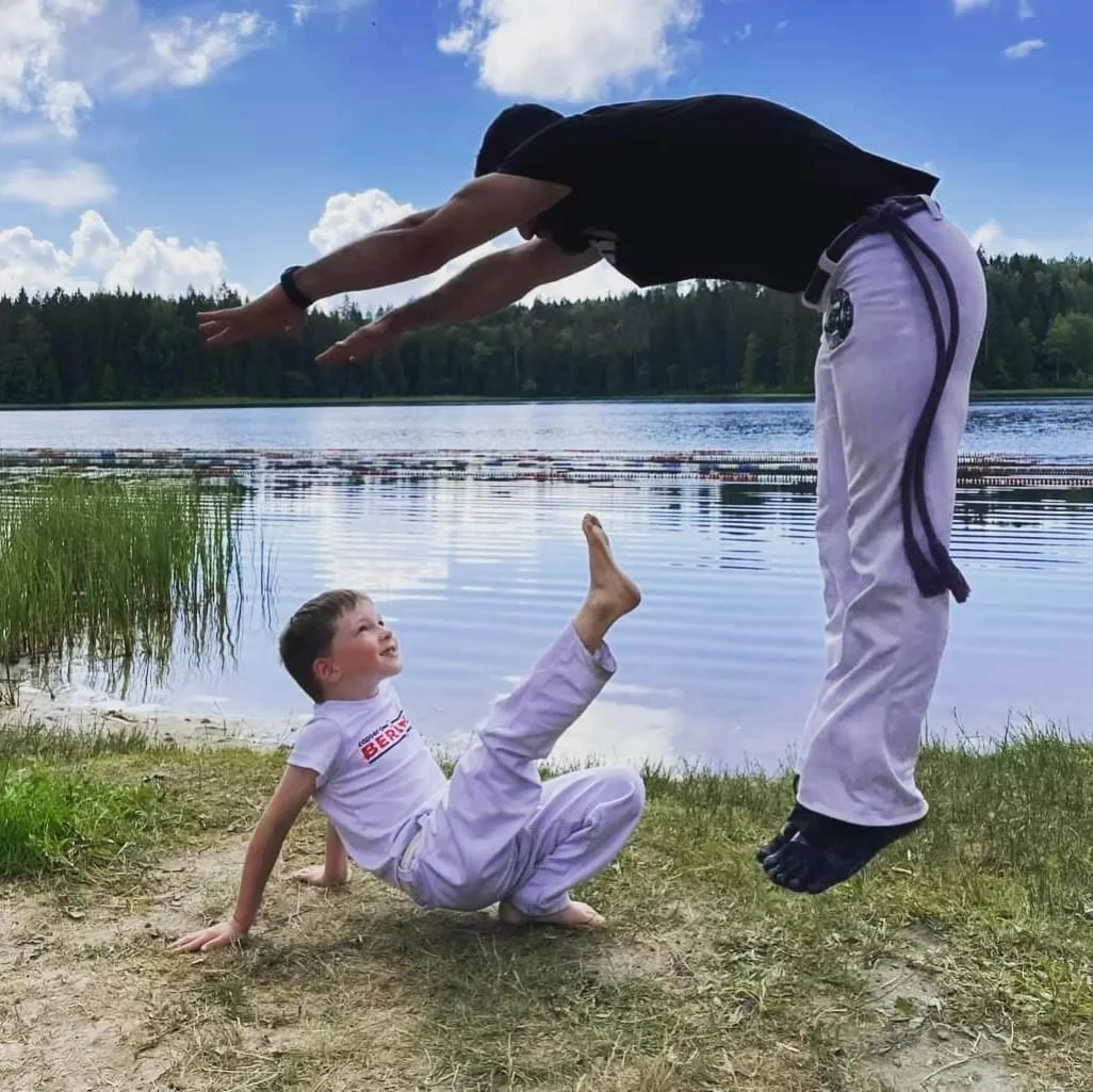 Capoeira training with a child outdoors
